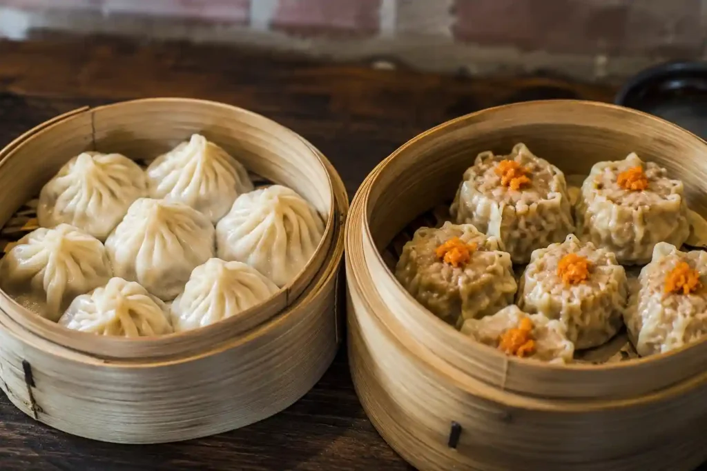 Steamed momos and siu mai dimsums in bamboo steamer basket — Momos vs Dimsums at The Red Palate Kolkata