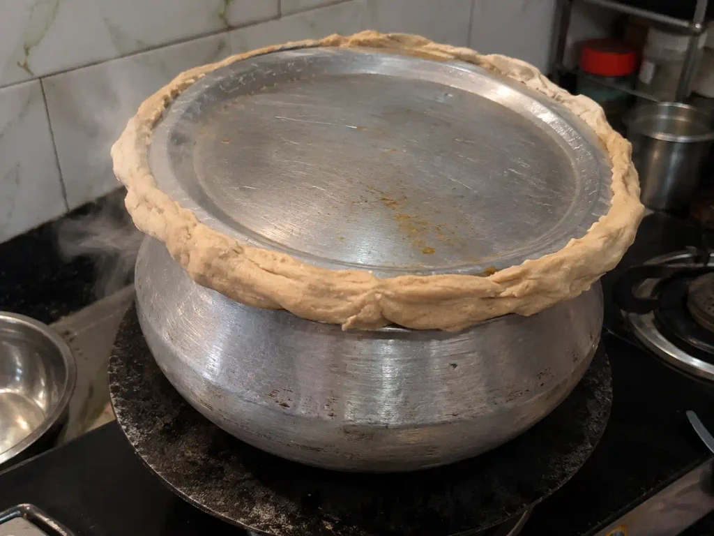 Handi sealed with atta dough on tawa for biryani dum cooking