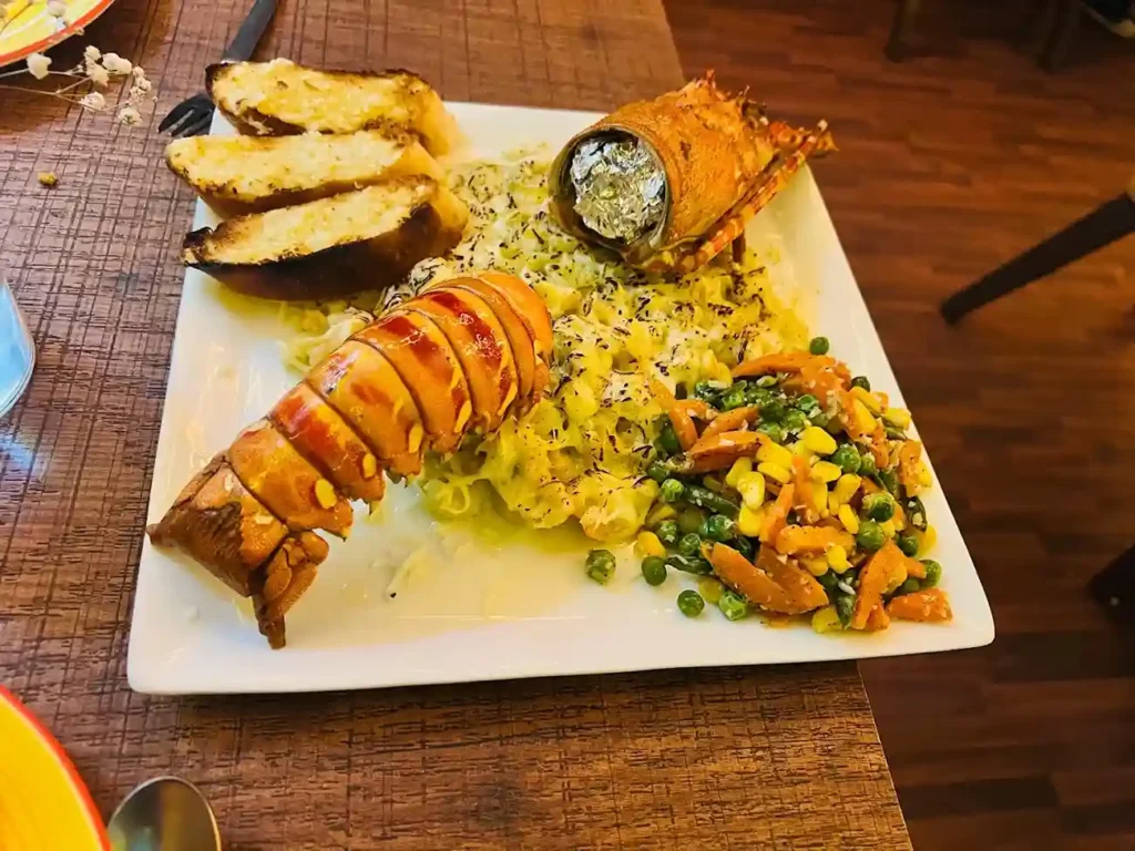 Grilled lobster tail at a seafood restaurant in Kolkata — served with herbed rice and garlic bread